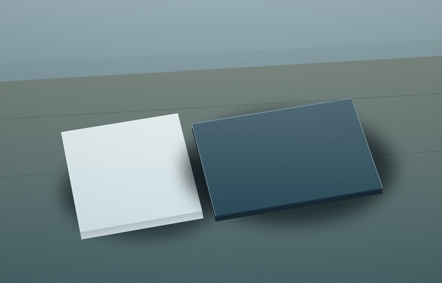 A stack of plain paper and a closed unmarked laptop on a wooden table.